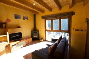 a living room with a couch and a tv at Cal Peretes - Apartamento de montaña en el Cadí in Arsèguel