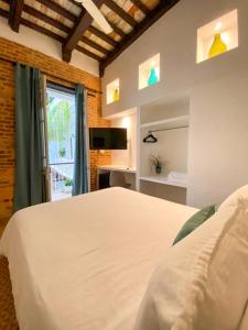a bedroom with a white bed and a window at Mosquito Boutique Hotel Zona Colonial in Santo Domingo