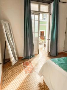 a bedroom with a bed and an open door at Mosquito Boutique Hotel Zona Colonial in Santo Domingo
