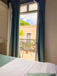 a bedroom with a bed and a view of a balcony at Mosquito Boutique Hotel Zona Colonial in Santo Domingo