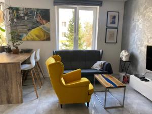 a living room with a couch and a table at Apartament Centrum- Art&Design in Konin