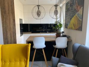 a kitchen with two yellow chairs and a counter at Apartament Centrum- Art&Design in Konin