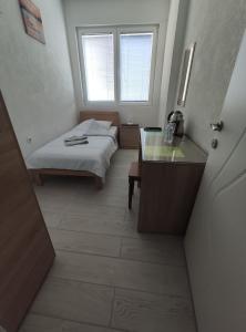 a bedroom with a bed and a desk and a window at Villa Ivanovi in Ohrid