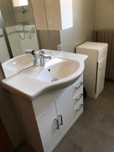 Un baño con lavabo, espejo y nevera. en Villa Le Rocher, en Villar-Saint-Pancrace 14 fotos más