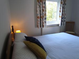 a bedroom with a white bed with a window at Ty Nain, Newport, Pembrokeshire in Newport Pembrokeshire