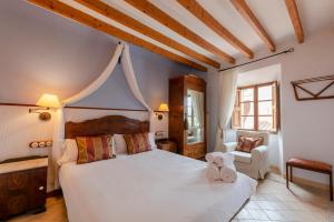 sypialnia z dużym białym łóżkiem i krzesłem w obiekcie Hotel D´Interior Ca Mado Paula w mieście Banyalbufar