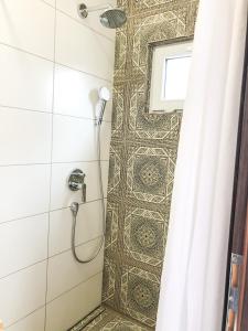 a shower in a bathroom with a tile wall at Kisas Loft By Pinch in Pakoštane