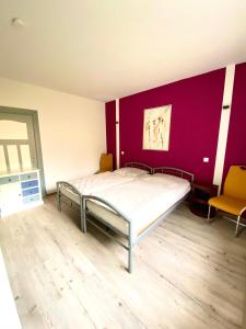 a bedroom with a bed and a purple wall at Schöne Ferienwohnung mit großem Garten in Flensburg +2 photos