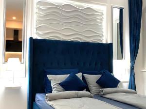 un letto blu con cuscini in una stanza con finestra di Studio Six a Umag (Umago)
