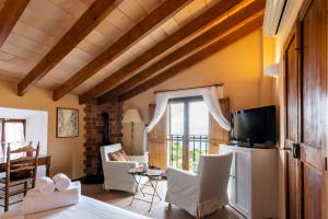 salon z telewizorem i białymi krzesłami w obiekcie Hotel D´Interior Ca Mado Paula w mieście Banyalbufar