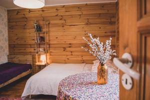 sypialnia z łóżkiem i wazonem z kwiatami na stole w obiekcie Pokoje Gościnne Nowy Świat w Supraślu