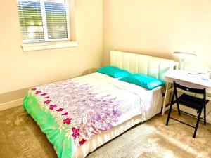 a bedroom with a bed with blue pillows and a desk at Deluxe House in Surrey