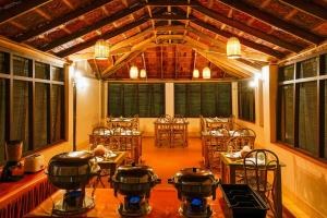 a room with tables and chairs with pots and pans at Zostel Homes Wayanad, Thirunelly in Wayanad