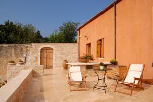 een patio met een tafel en stoelen en een gebouw bij Villa Irini in Vafés