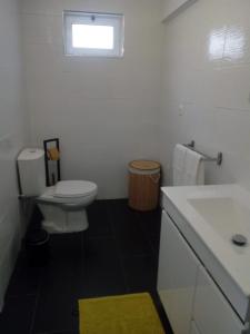 a bathroom with a white toilet and a sink at Casa do soito in Mangualde