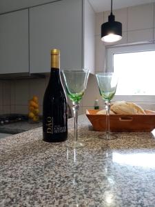 a bottle of wine and two glasses on a kitchen counter at Casa do soito in Mangualde