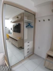 Habitación con espejo, escritorio y TV. en Smart Residence Flat - FLAT 605, en Teresina