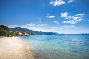 - une vue sur une plage avec des montagnes en arrière-plan dans l'établissement Aminess Bellevue Village, à Orebić