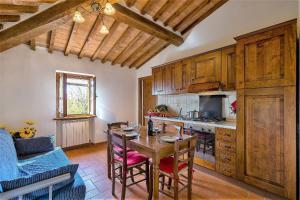 a kitchen with a wooden table and a dining room at Agriturismo La Fragola in Cignano