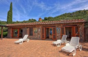 a group of chairs sitting in front of a building at Villa Raggio Di Sole in Porto Santo Stefano
