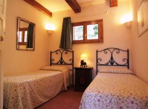 a bedroom with two beds and two windows at Villa Raggio Di Sole in Porto Santo Stefano
