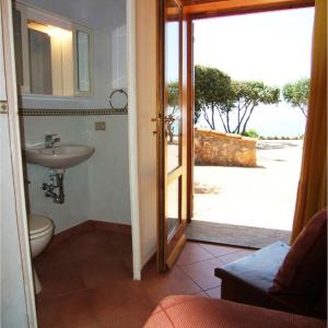 a bathroom with a sink and a door to a yard at Villa Raggio Di Sole in Porto Santo Stefano