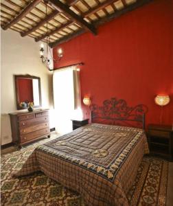 トラーパニにあるLa Lamparaの赤い壁のベッドルーム1室(ベッド1台付)