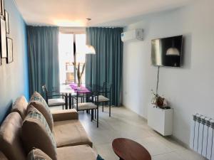 - un salon avec un canapé et une salle à manger dans l'établissement Apartamentos boutique Cordoba, à Córdoba