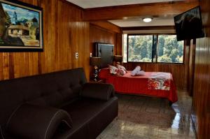 a living room with a couch and a bed at Hotel "La Cabaña de Don Adolfo" in Zacatlán