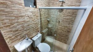 a bathroom with a toilet and a glass shower at Cantinho da Sarah in Maragogi