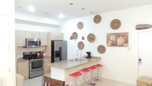 a kitchen with a counter with red stools at La Isla Residences Luxury Condominiums in South Padre Island