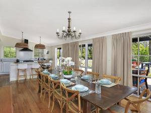 a dining room and kitchen with a table and chairs at Duncraig House in Bundanoon