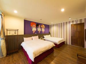 a bedroom with two beds and a painting on the wall at Kenting Lian Nan Wan in Nanwan