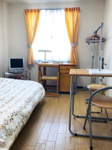 Un dormitorio con una cama y un escritorio y una ventana. en Gojyo Ivy, en Kioto