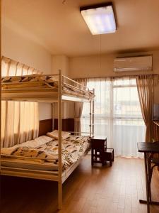 1 dormitorio con 2 literas y ventana en Fushimi Ivy, en Kioto