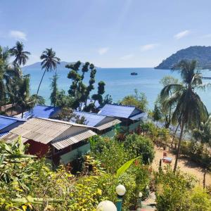 a house with solar panels on a beach next to the ocean at Rasta view Bangalows in Ko Chang