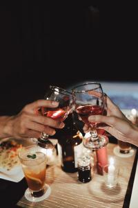 two people are holding wine glasses on a table at Paduppa Resort in Bira