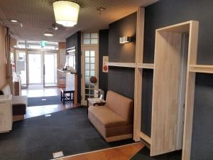 a living room with a couch and a hallway at Tsukuba Daily Inn in Tsukuba
