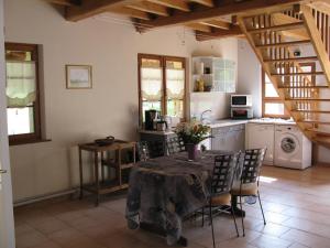 a kitchen with a table and chairs in a room at La Bergerie du festel in Saint-Riquier