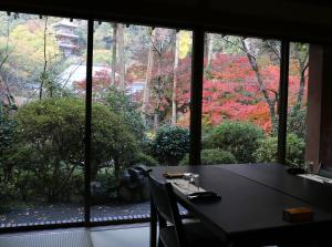 stół i krzesła w pokoju z oknem w obiekcie Ryokan Koyokan w mieście Yasugi