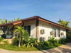 a house with palm trees in front of it at Lamphurai Riverside Resort and Spa in Trat