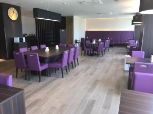 a dining room with purple chairs and a table at Kochi Hotel in Kochi