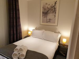Birmingham Garnet, 3 bedroom Apartment في برمنغهام: غرفة نوم عليها سرير وفوط