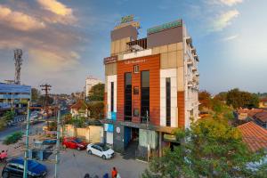 a building in a city with cars parked in a parking lot at Safa Residency in Tiruchchirāppalli