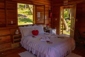 a bedroom with a bed with a heart on it at Pousada Cascata Véu de Noiva in Urubici