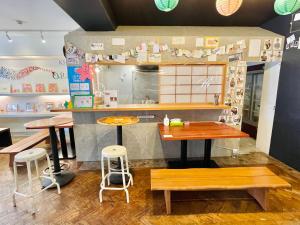 a kitchen with a table, chairs and a refrigerator at Khaosan Tokyo Origami in Tokyo