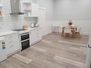 a kitchen with white cabinets and a table with chairs at The Bend Abode in Tailem Bend
