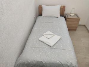 a bed with a white towel on top of it at Villa Ivanovi in Ohrid