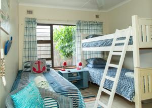 a bedroom with two bunk beds and a desk at Sea View townhouse in Zinkwazi Beach in Zinkwazi Beach