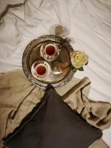 a plate with two cups of tea on a bed at B&b Villa Rosalia in Procida